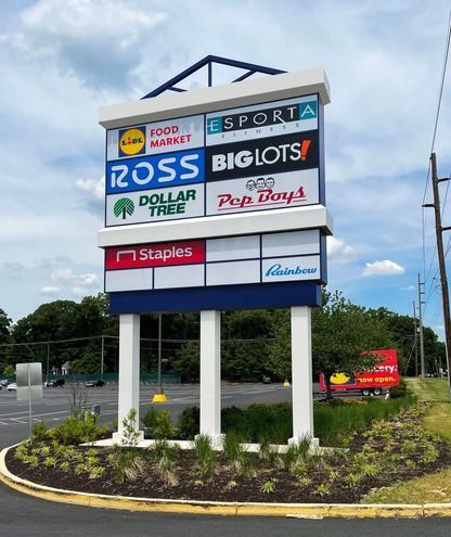 A large sign for ross big lots is sitting in the middle of a parking lot.