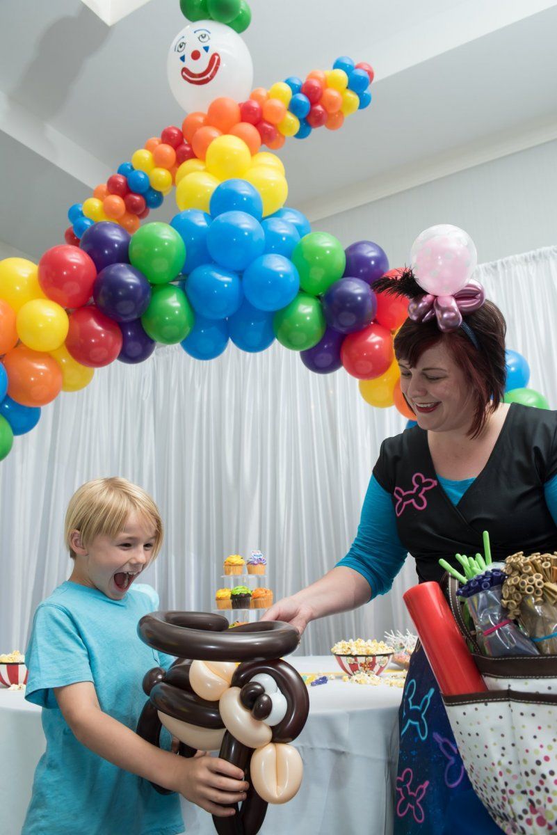 A woman and a boy are playing with balloons at a party. Balloon Twisting Entertainment.