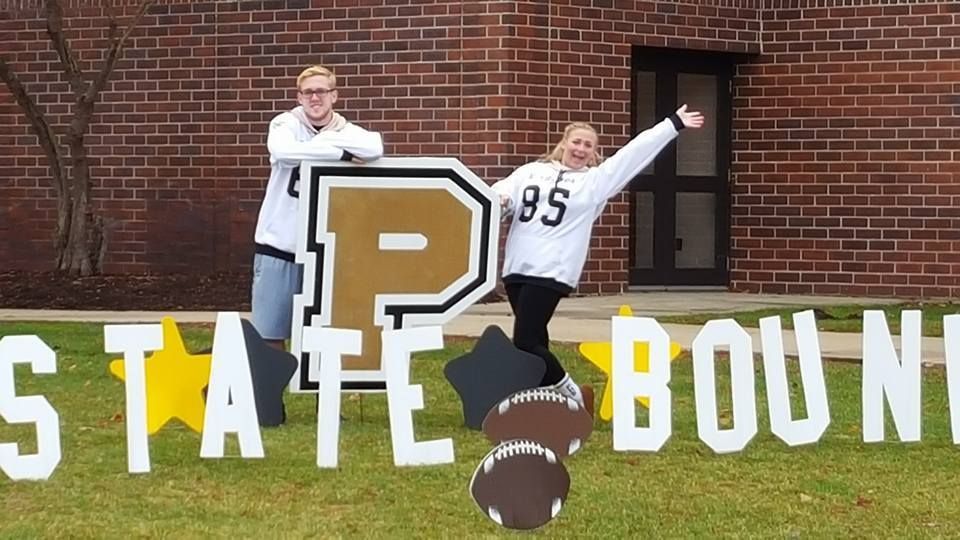 Two people standing in front of a sign that says state bound