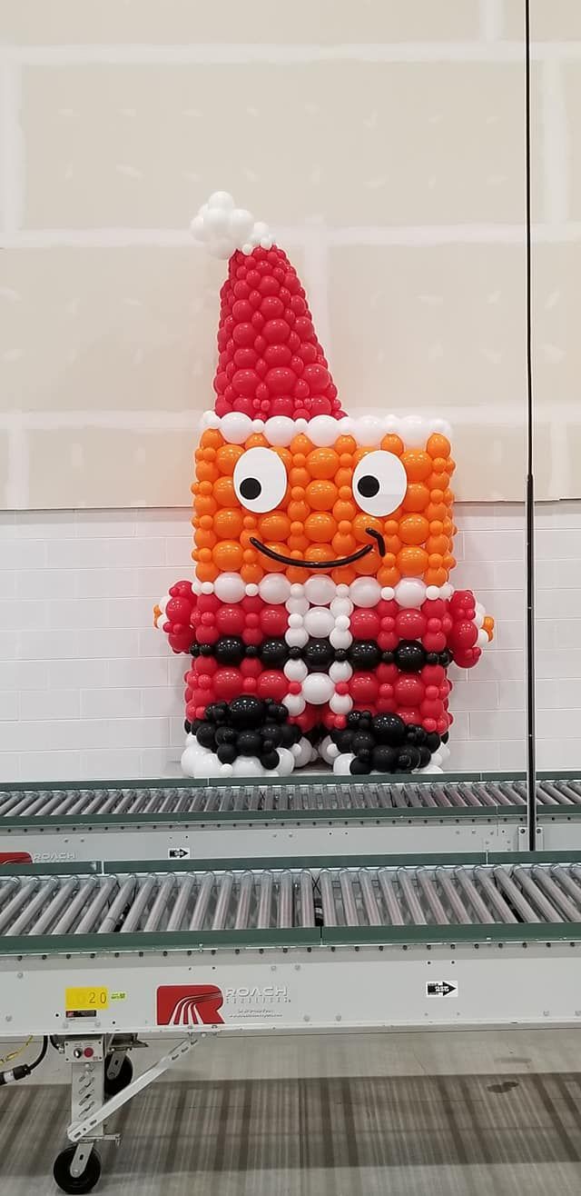A stuffed animal made out of balloons is sitting on a conveyor belt.