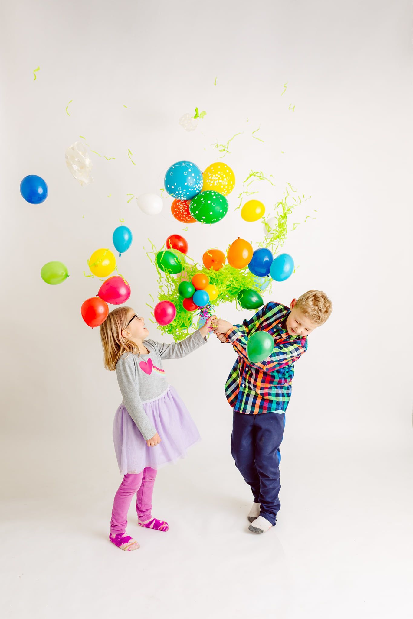 A boy and a girl are playing with balloons.  Pop Drop