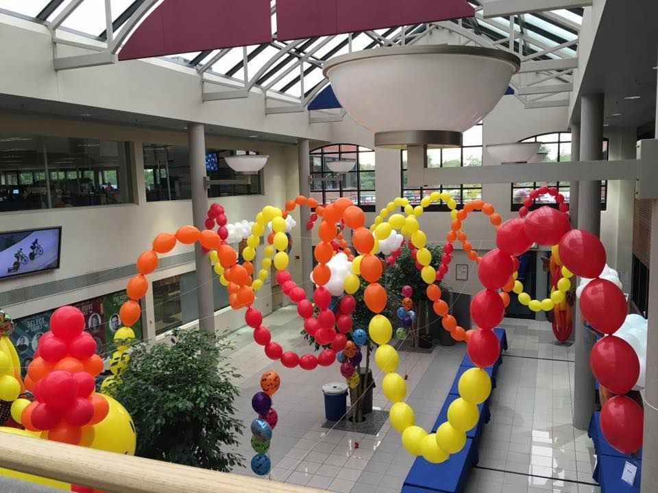 Interior view of a building atrium decorated with colorful balloon art.