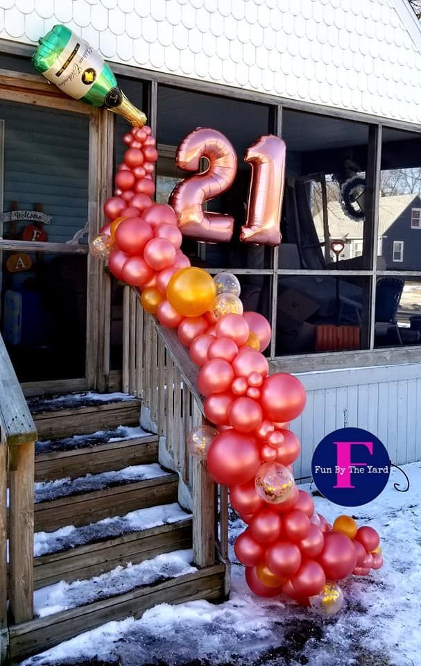 A champagne bottle balloon with cascading red balloons and