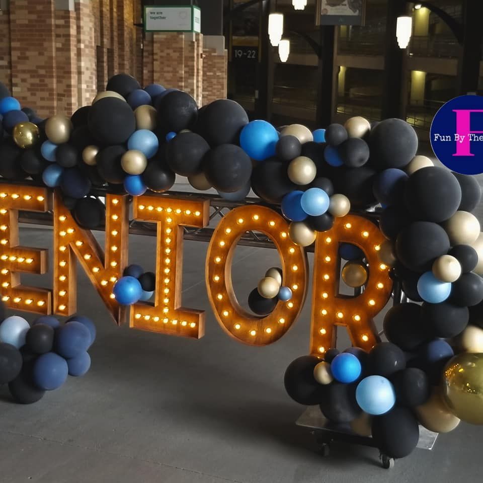 a sign that says senior is surrounded by balloons