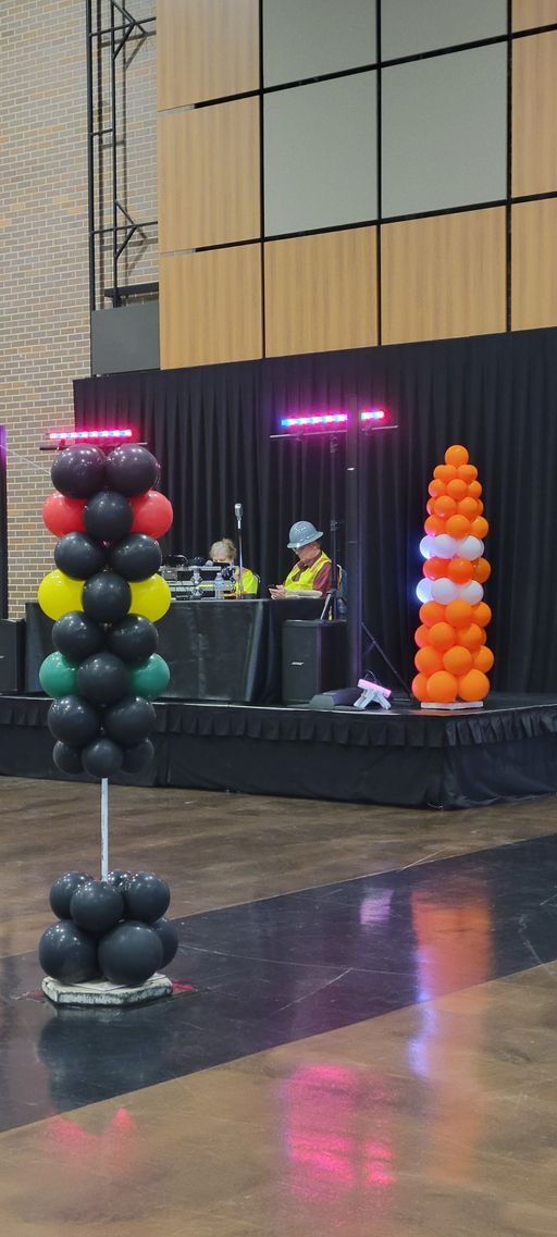 A group of balloons are sitting on top of a stage in a room.