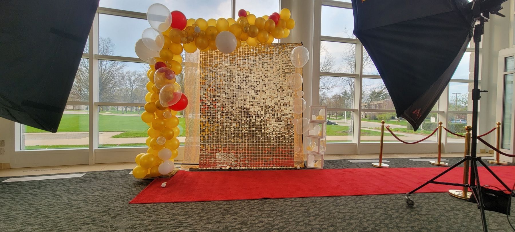 A room filled with balloons and a red carpet.