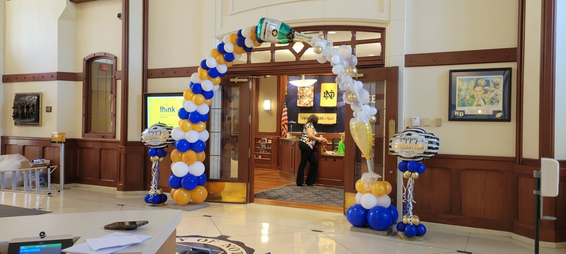 A room decorated with balloons and a woman standing in front of a door.