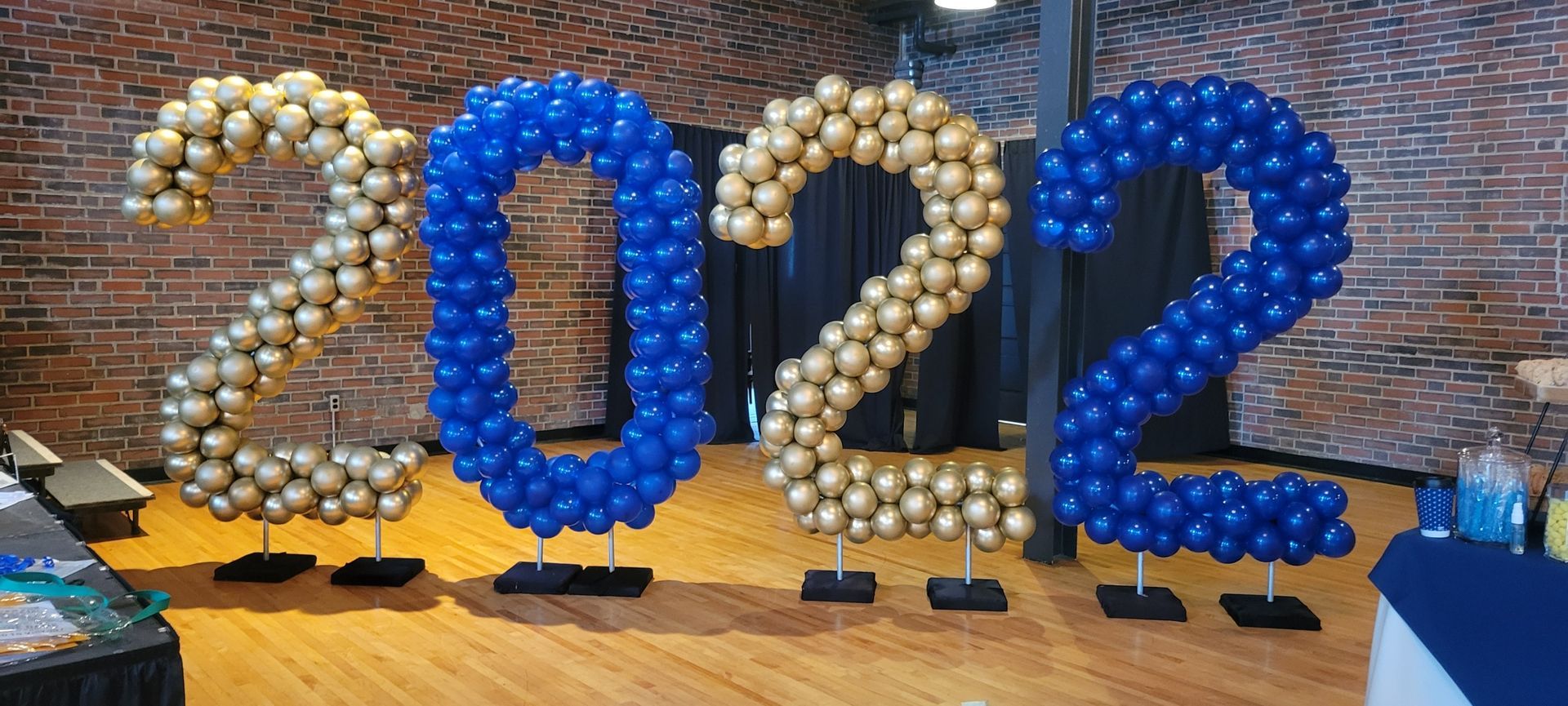 The numbers 2022 are made of blue and gold balloons.
