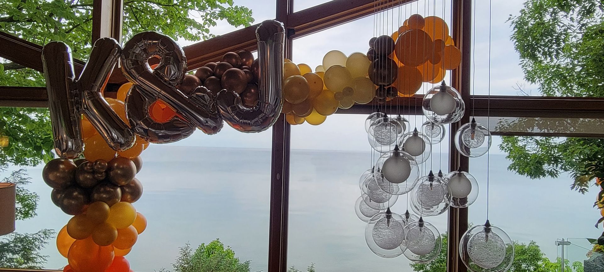 A window with balloons hanging from it and a view of lake Michigan
