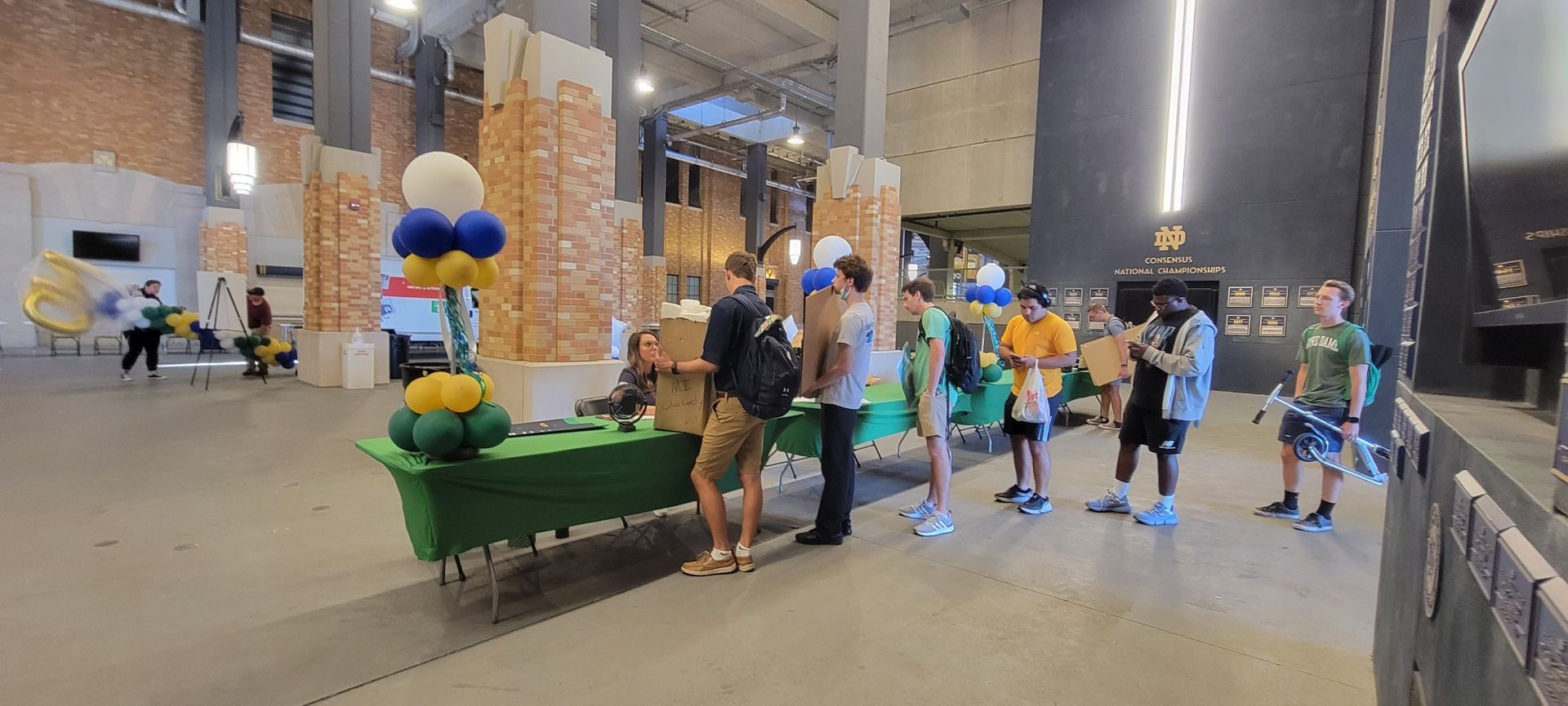 a group of people are standing around a table in a large room