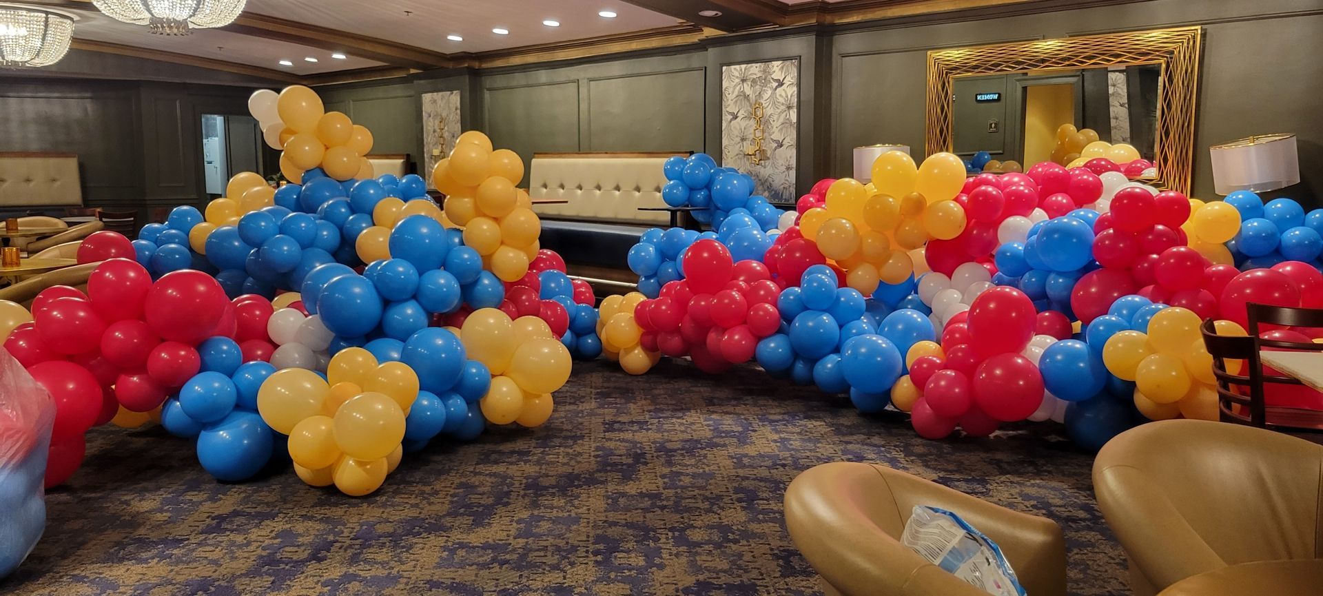 A room filled with lots of colorful balloons and chairs.