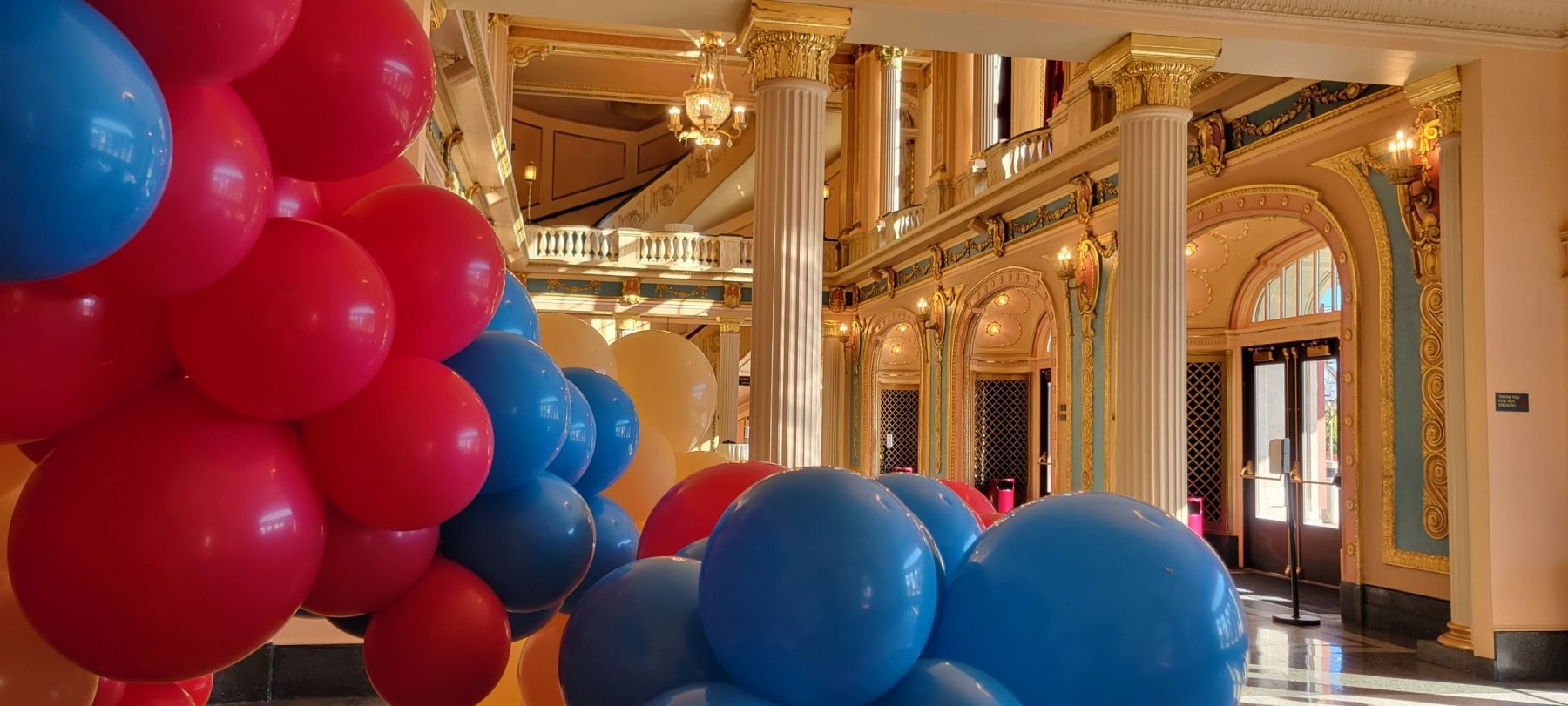 A bunch of red and blue balloons are sitting in a room.