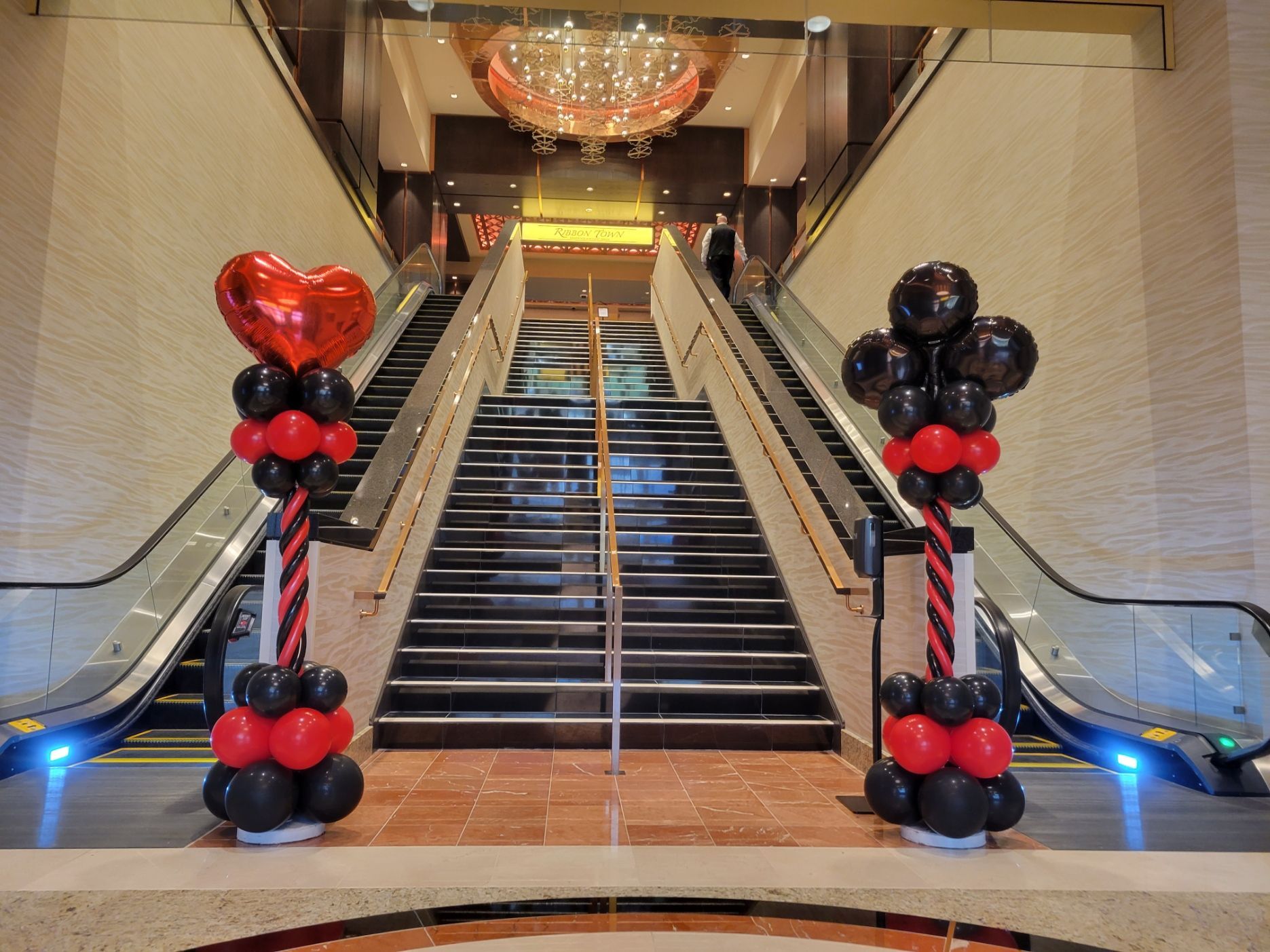 The stairs are decorated with red and black balloons. Casino themed balloon decor