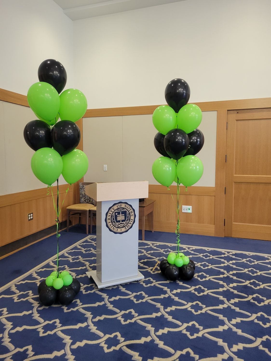 A podium with green and black balloons in front of it