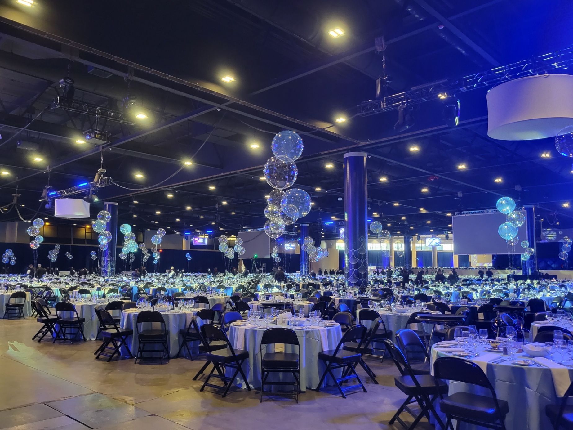 A large room with tables and chairs set up for a party.