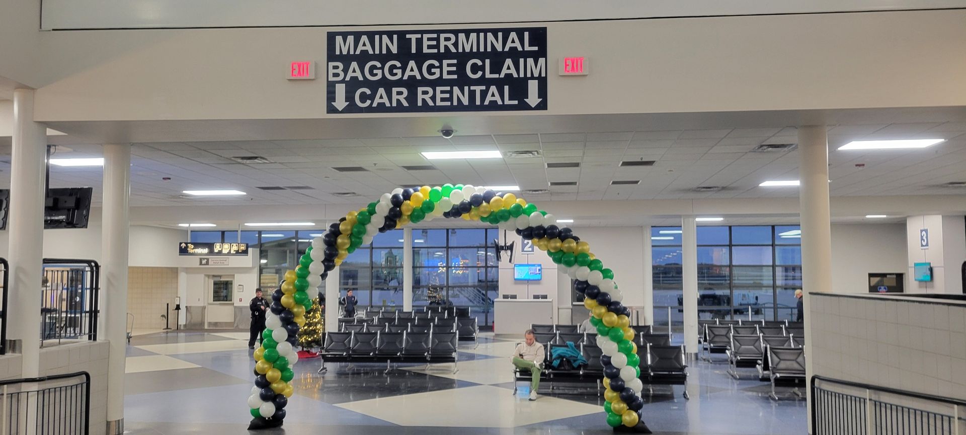 A large room with balloons and a sign that says main terminal baggage claim car rental.  South Bend International Airport