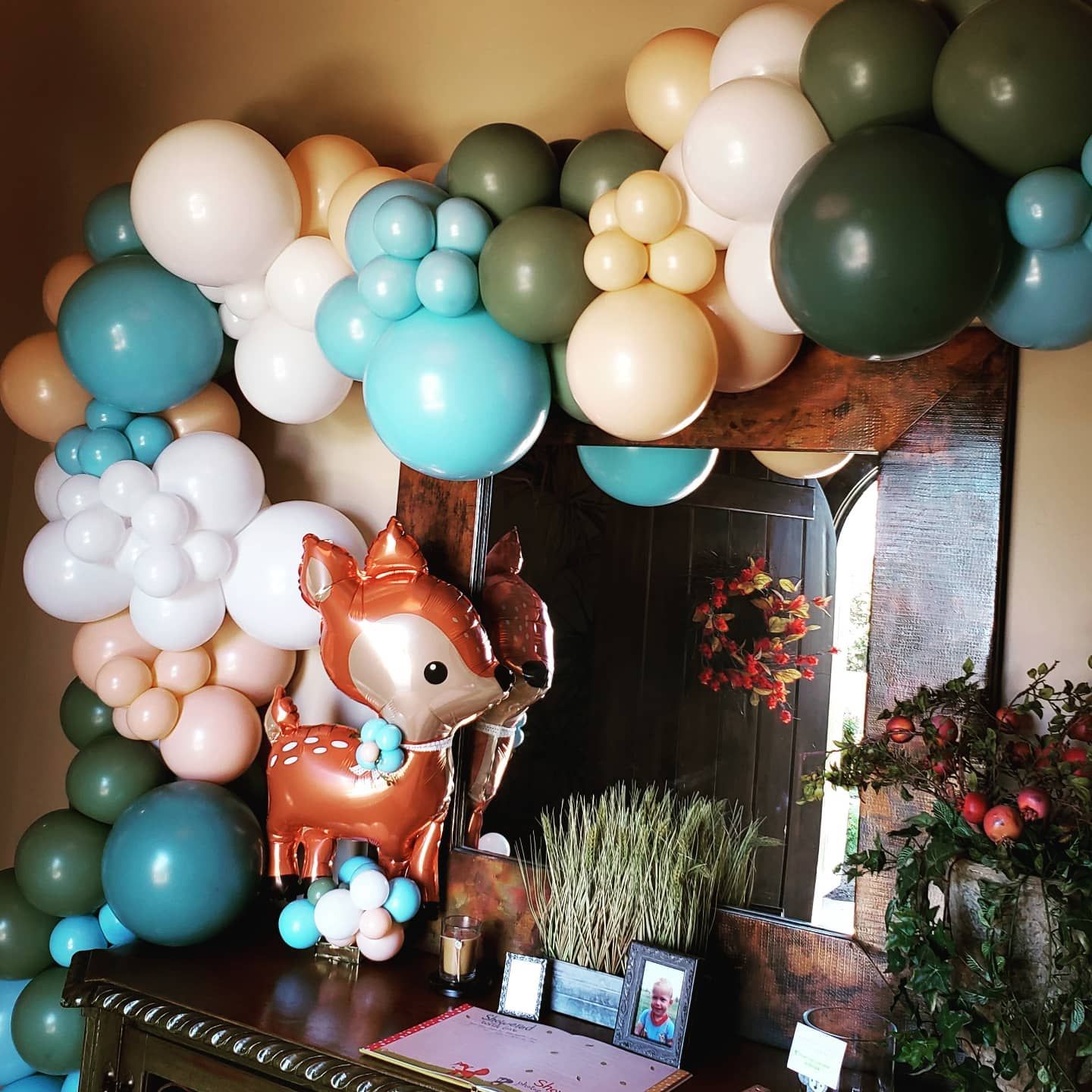 A deer balloon is surrounded by balloons in a room
