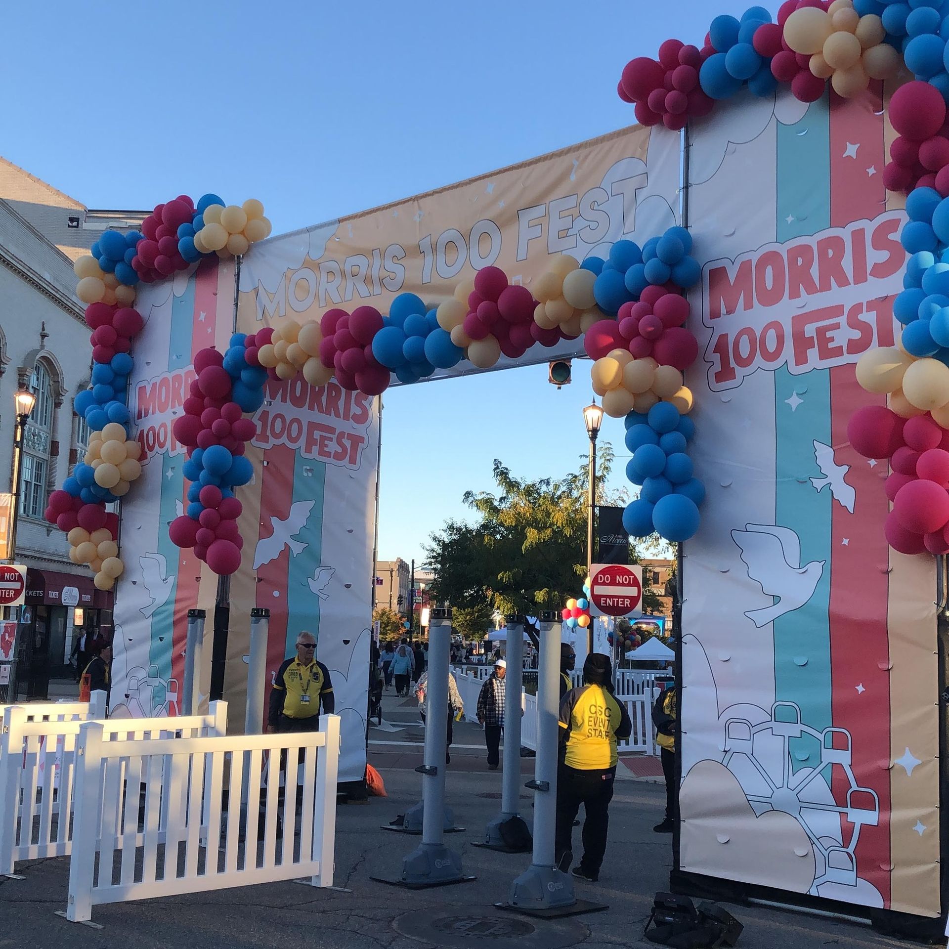 A sign that says morris 100 fest is decorated with balloons