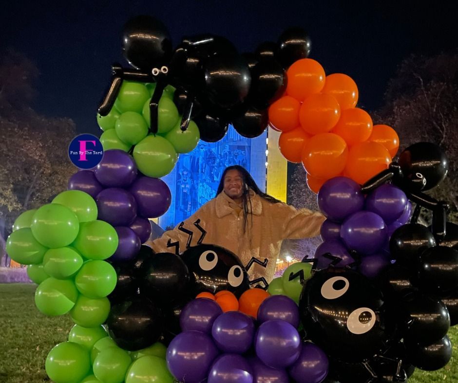 A woman is standing in a circle of halloween balloons