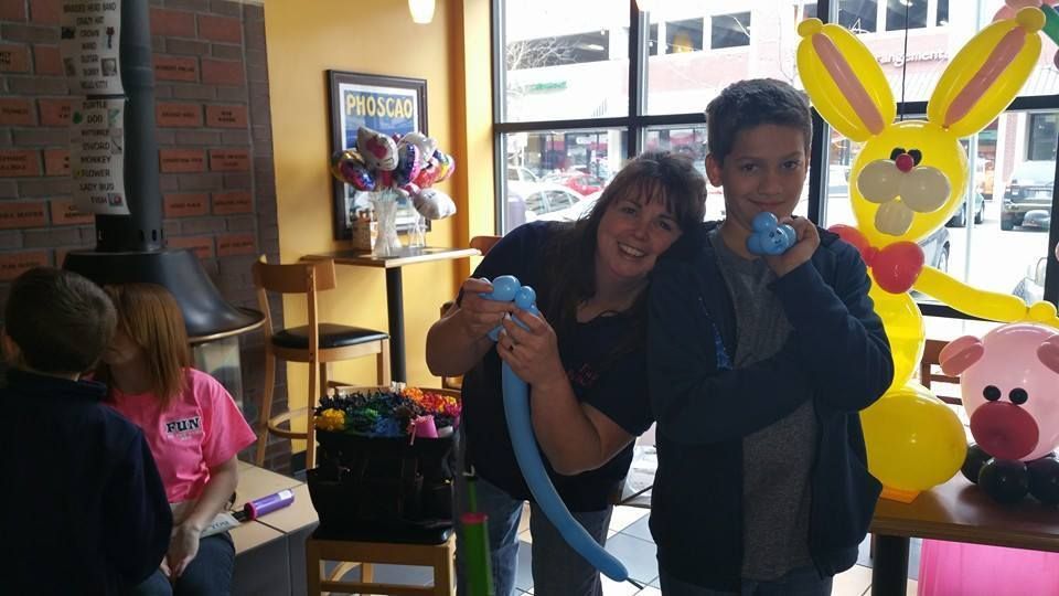 A boy and a woman are blowing up balloons in a room. Easter balloon bunny. Balloon Twisting Entertainment