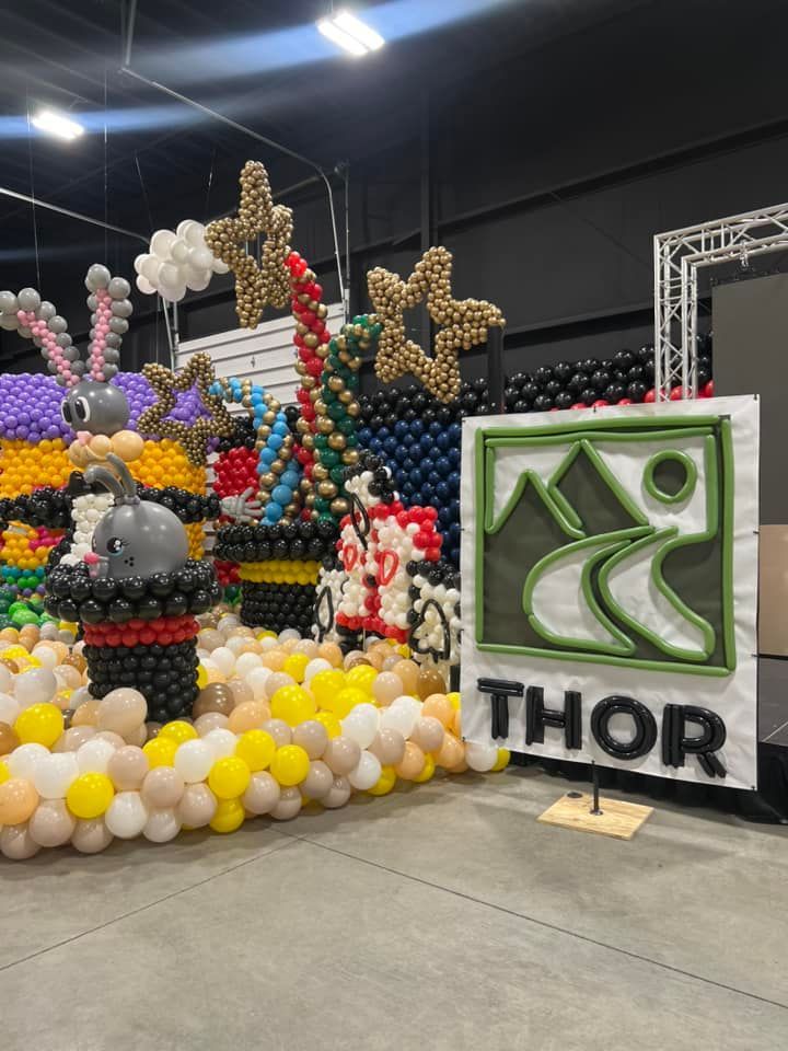 A sign that says thor is surrounded by balloons