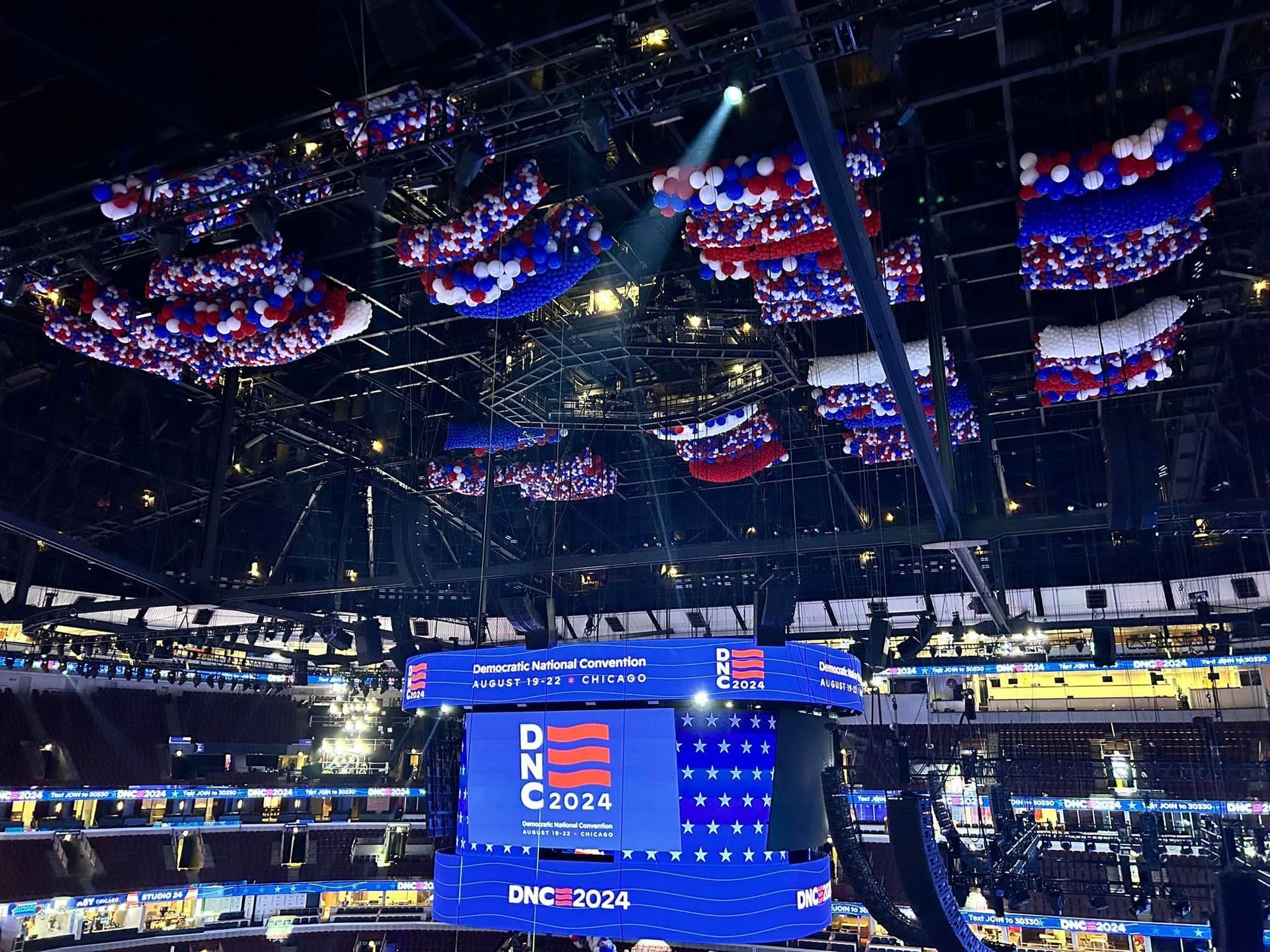 A large screen in a stadium says dnc 2024. Balloon Drop