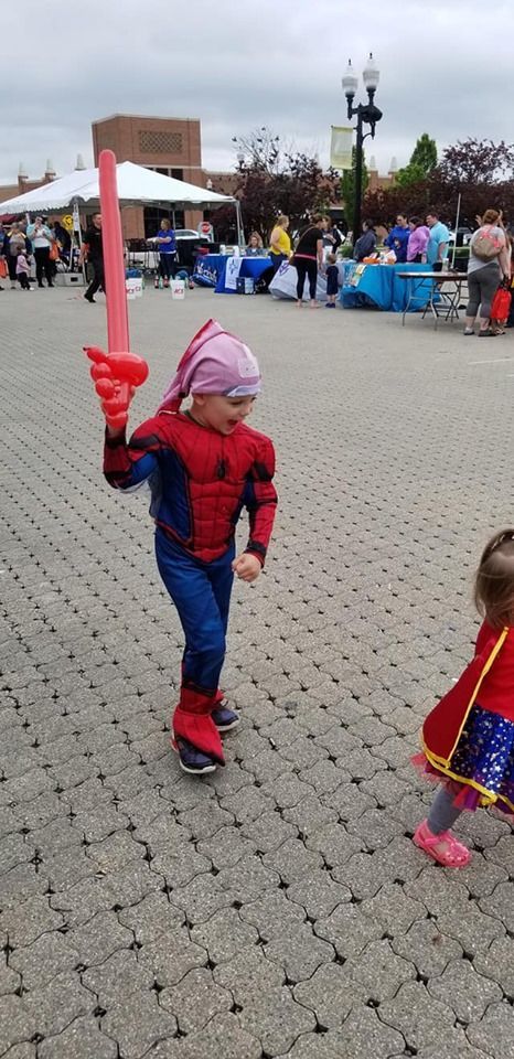 Happy boy in Spiderman costume holding a balloon animal
