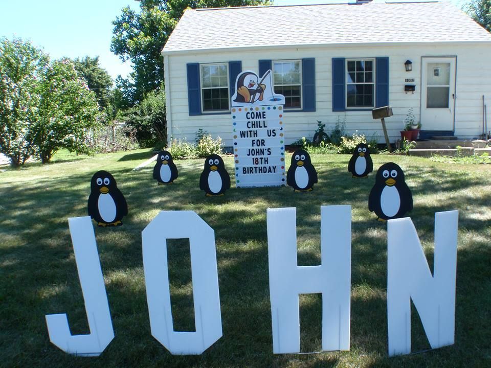 A white house with penguins and the name john.  Penguin themed yard card.