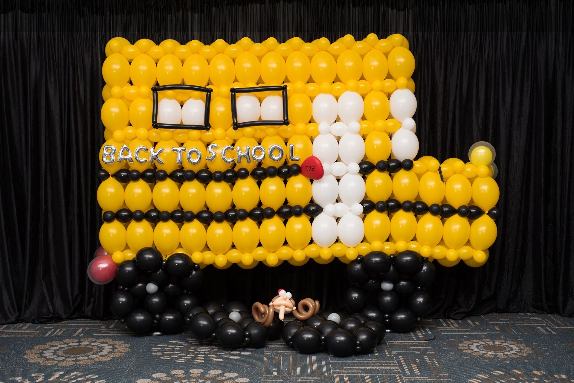 A school bus made out of balloons with the words `` back to school '' written on it.