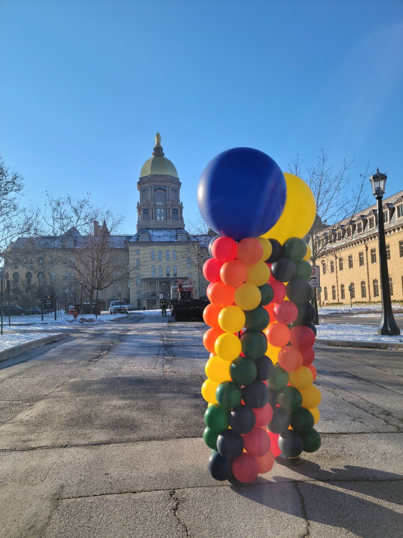 a bunch of balloons on a pole in front of a building