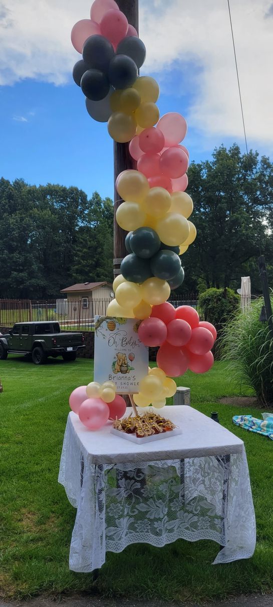 A table is decorated with balloons and a cake on it.