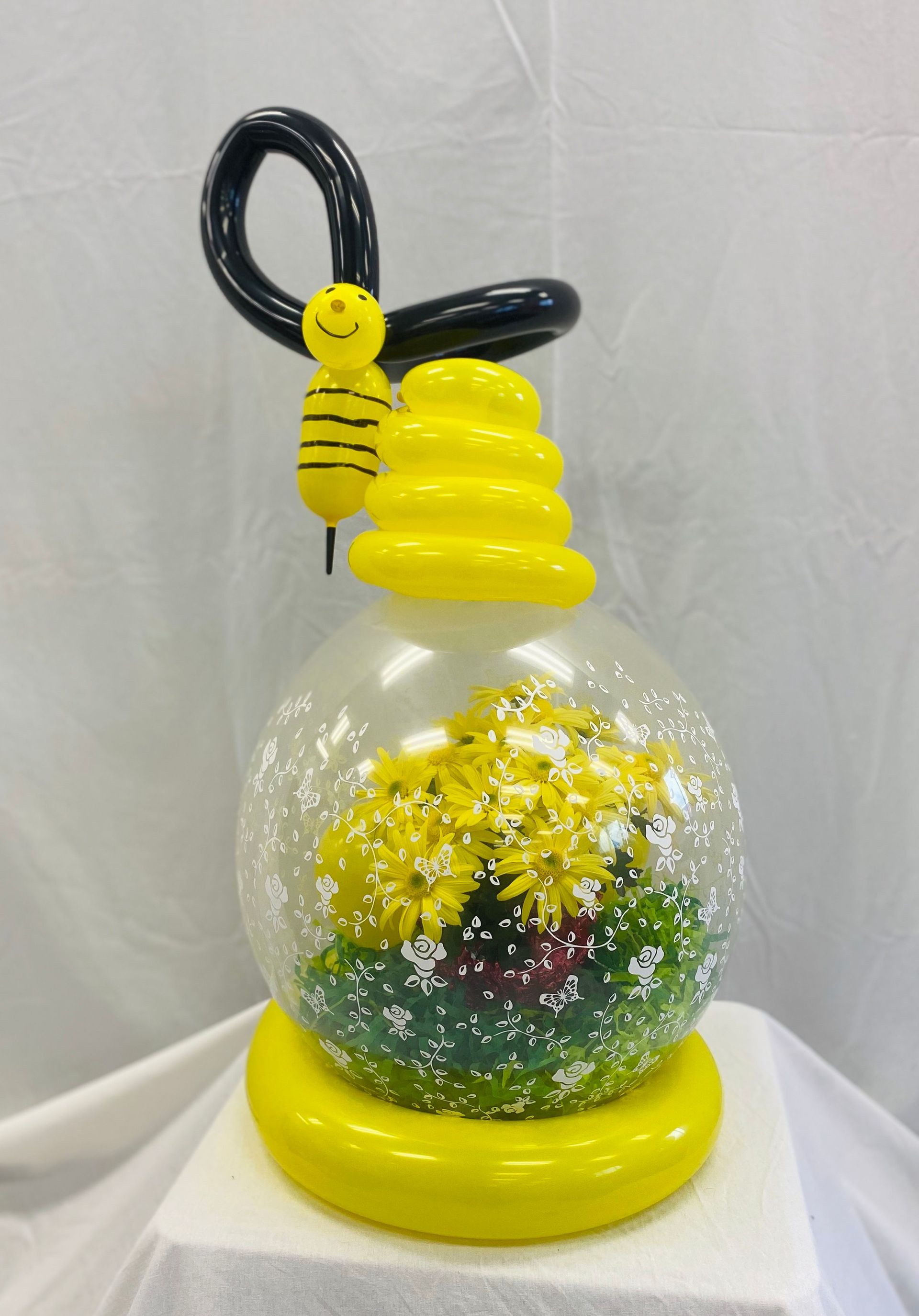 A balloon with a bee and flowers inside of it