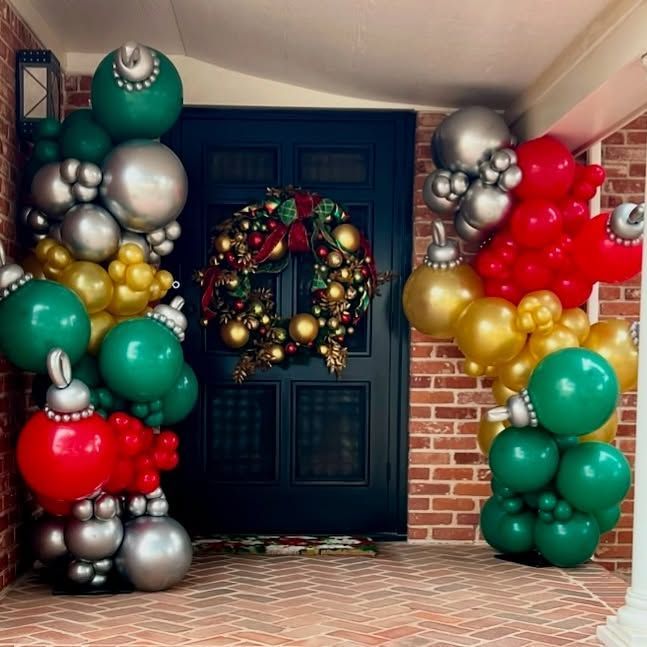 Christmas decorations: door with wreath, balloon ornaments in red, green, gold, and silver.