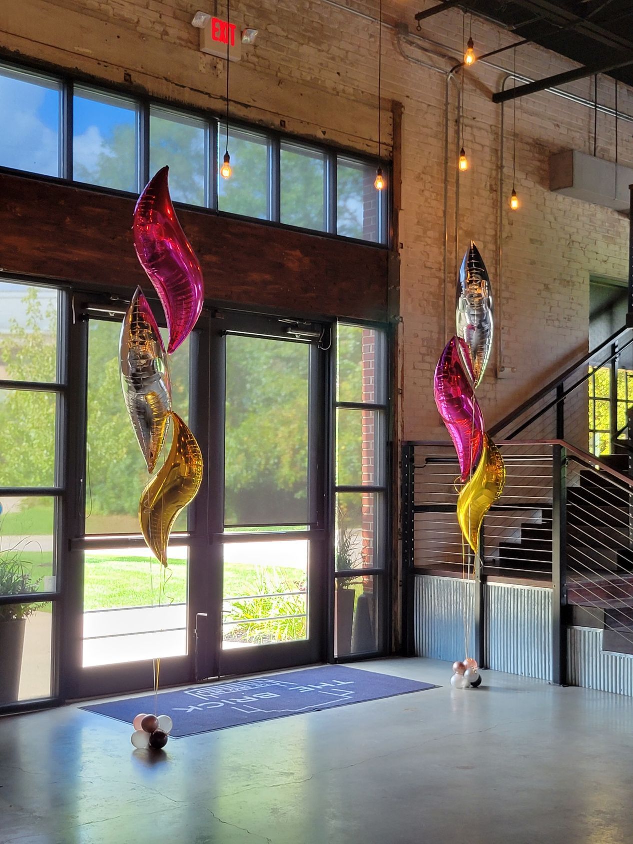 A bunch of balloons are hanging from the ceiling in a room