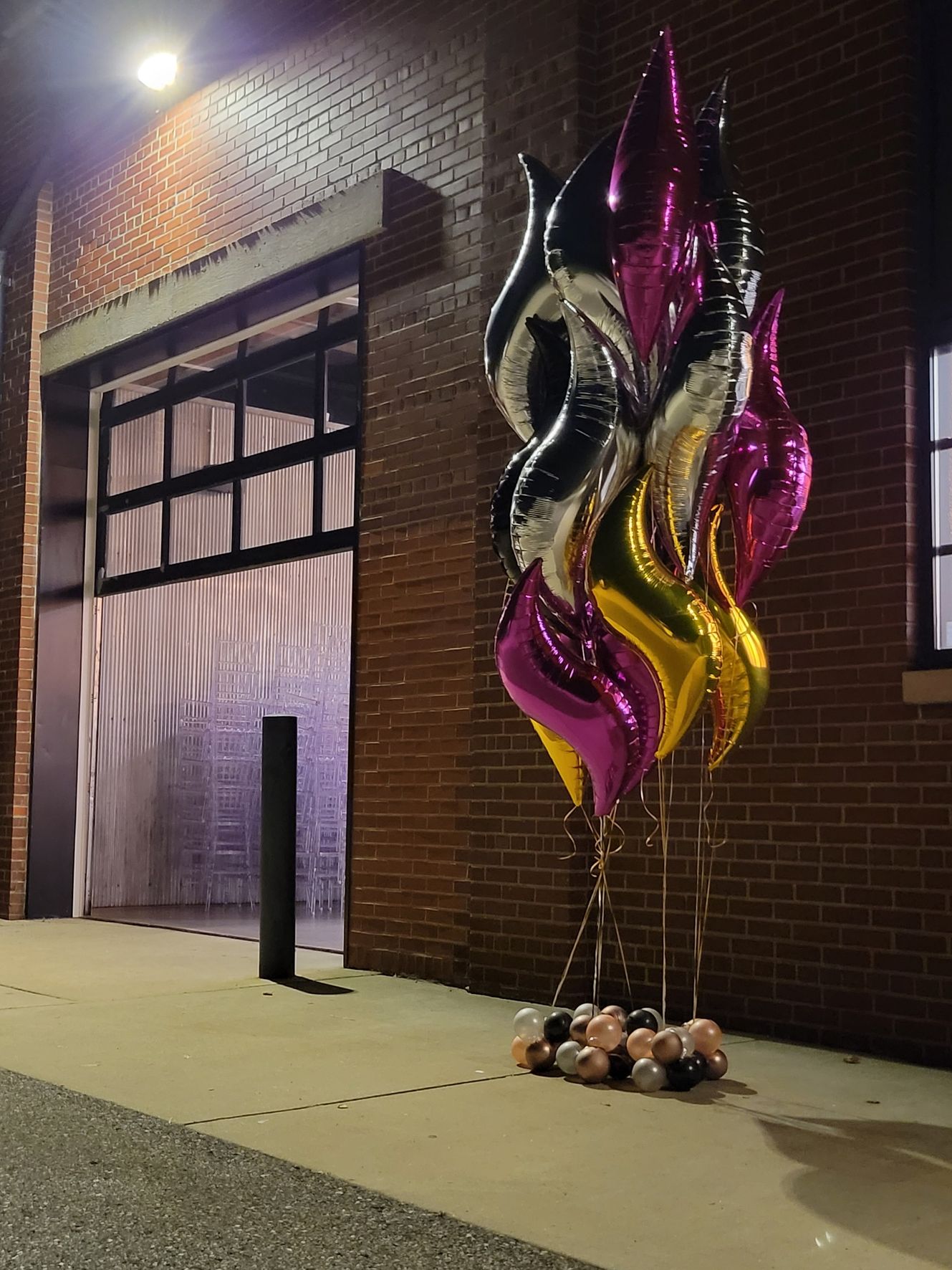Helium balloons in front of a brick building