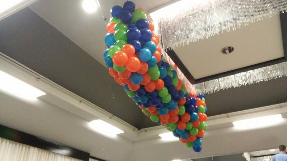 A bunch of colorful balloons hanging from the ceiling