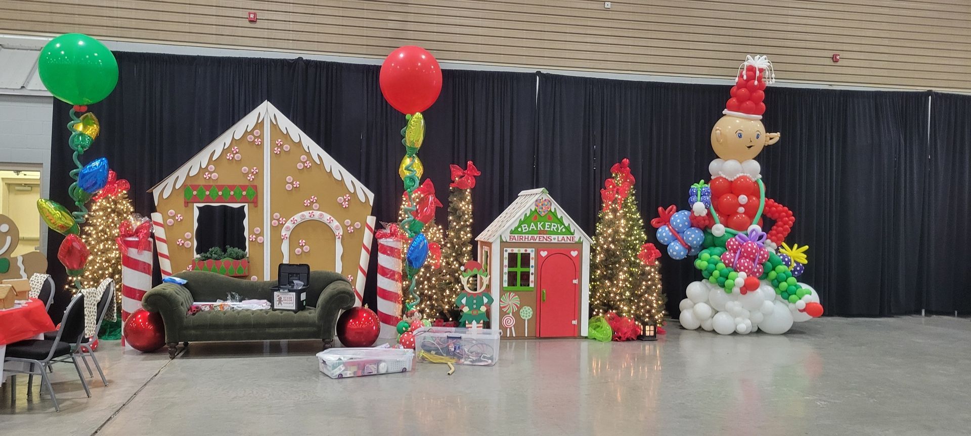 Christmas themed balloon decorations featuring a gingerbread house, trees, and snowman.