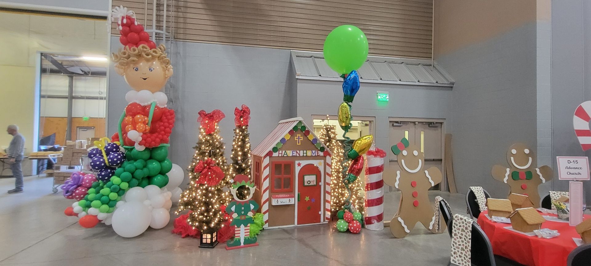 Christmas balloon decorations: elf, trees, gingerbread house, characters, red and green.