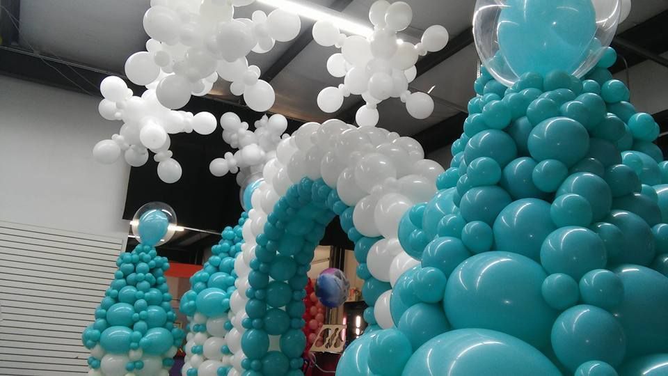A bunch of blue and white balloons shaped like trees and snowflakes