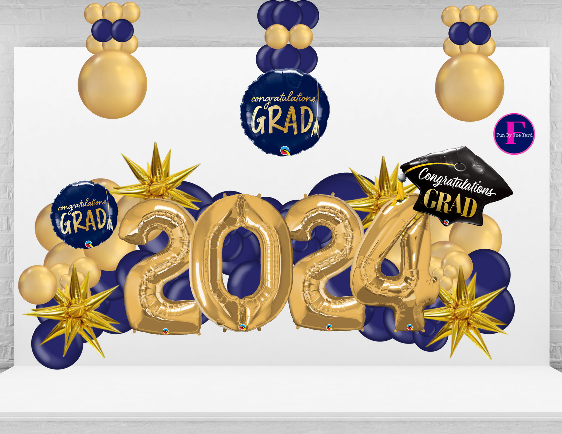 A picture of a graduation decoration with balloons and a graduation cap.