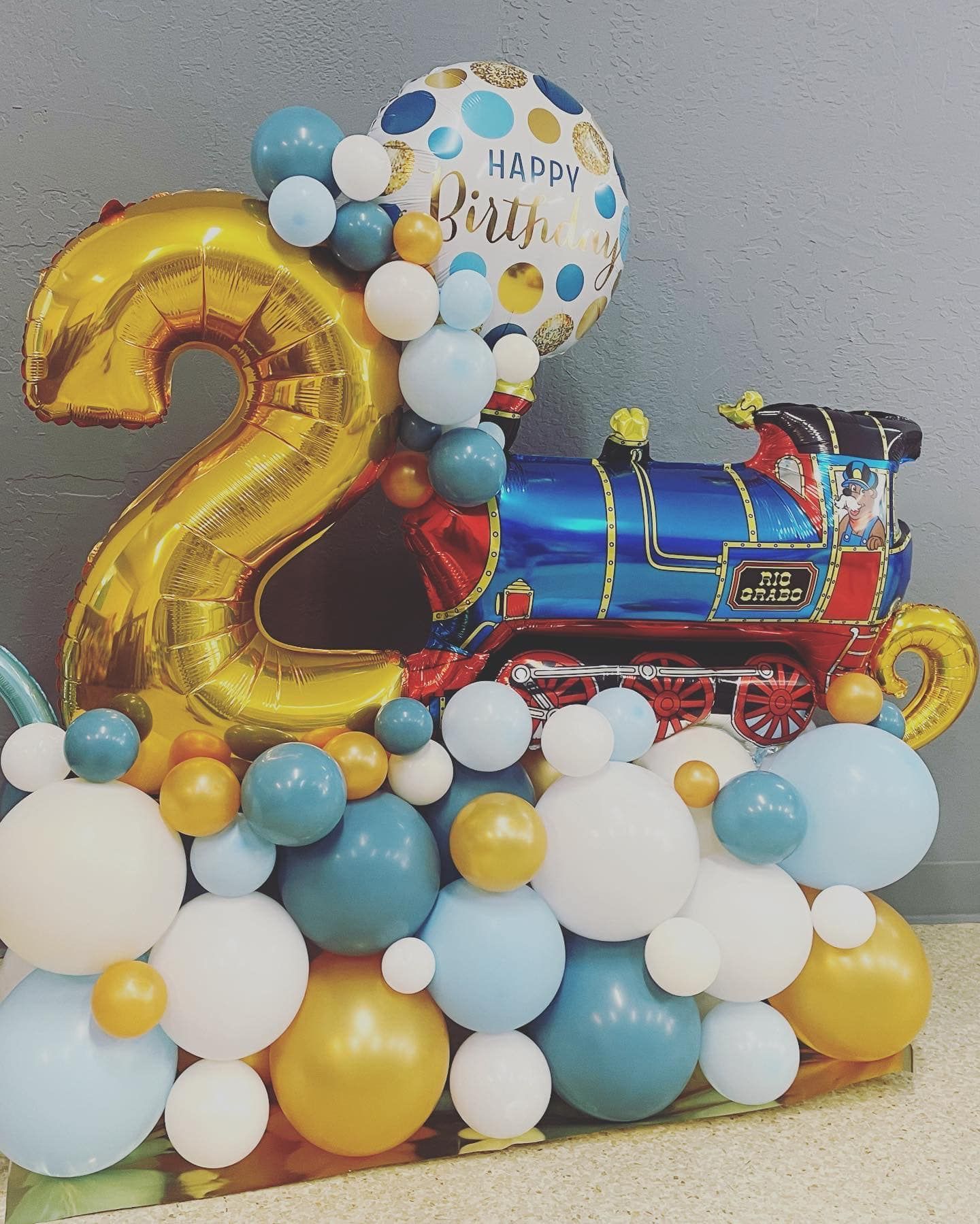 Balloon train decoration with a gold number 2 and
