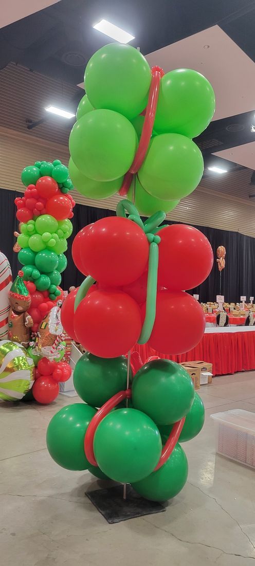 Balloon column: green, red, and orange balloons. An indoor setting with food in the background.