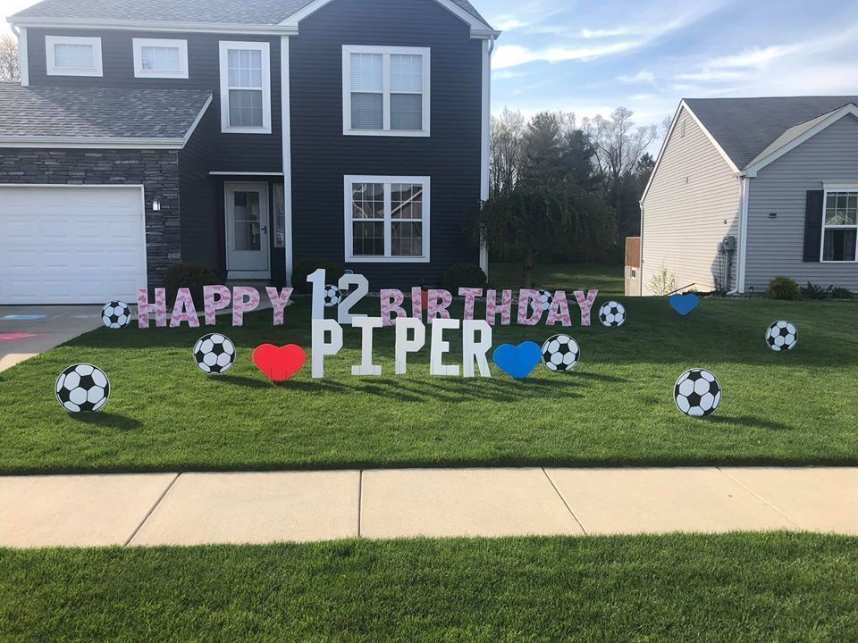 A black house with a happy 12th birthday sign in front of it.