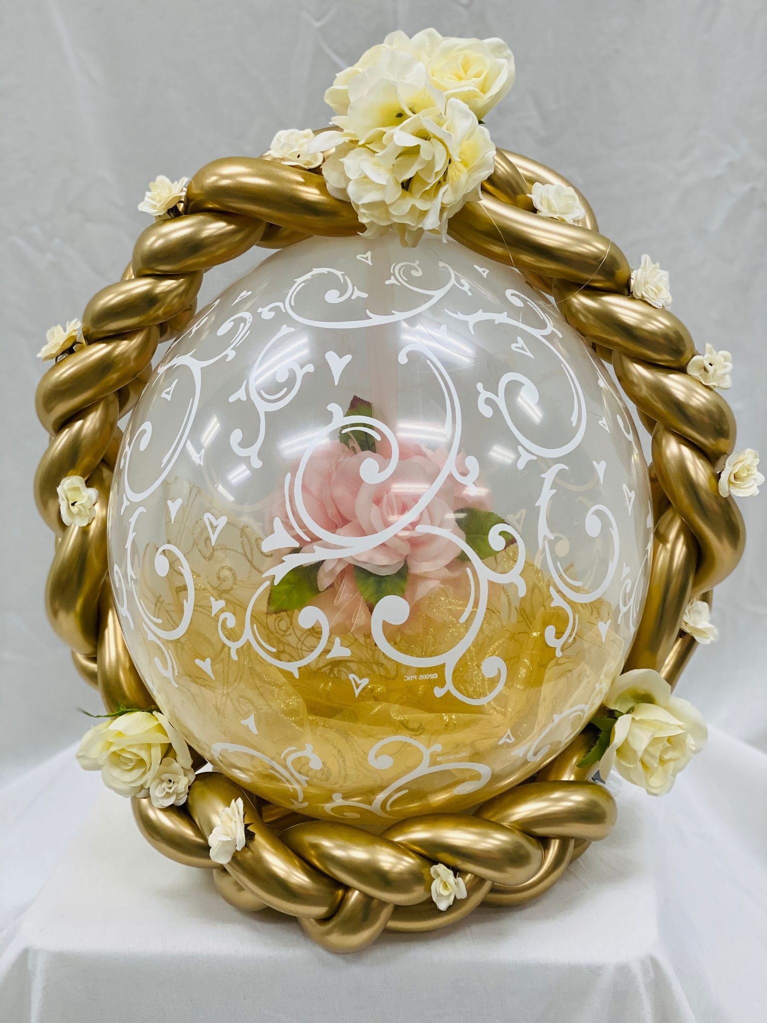 A balloon with flowers inside of it is sitting on a table.