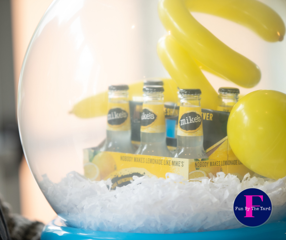 A snow globe filled with bottles of mikes lemonade. Stuffed balloon gift