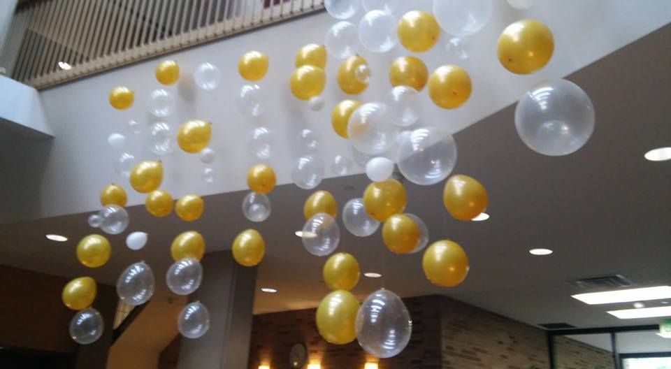 A bunch of balloons are hanging from the ceiling in a room.