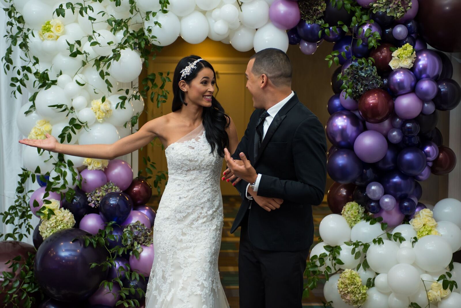 Bride and groom on wedding day with balloon décor backdrop
