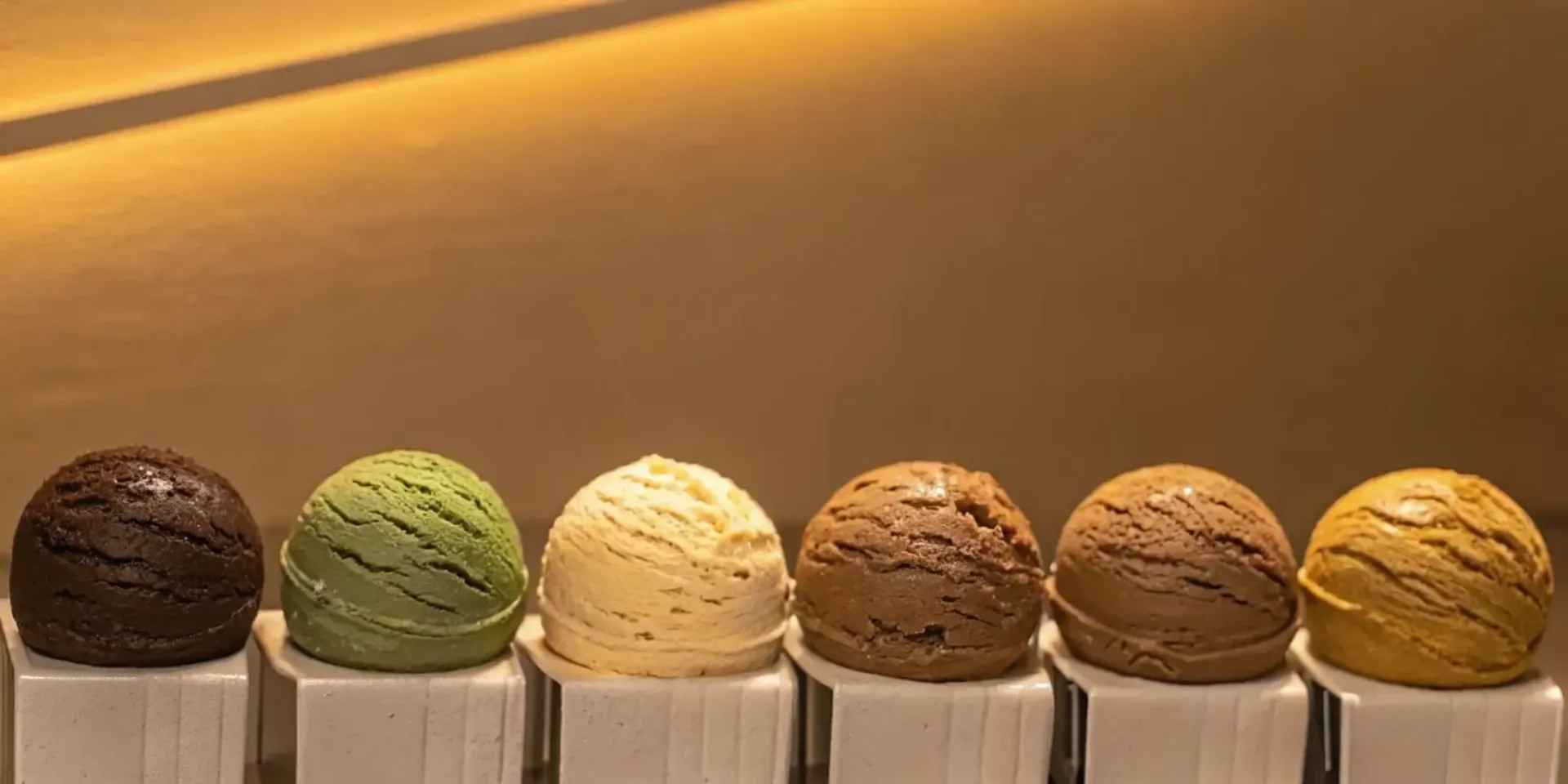 Six colorful scoops of premium ice cream lined up for comparison.