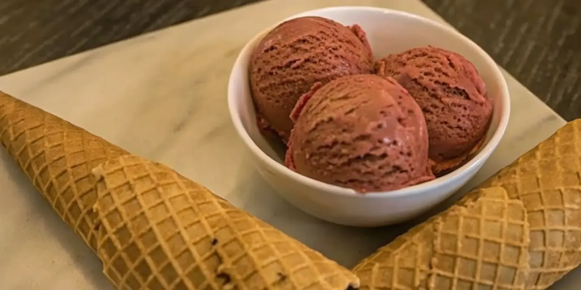 Red velvet ice cream in a bowl with waffle cones.