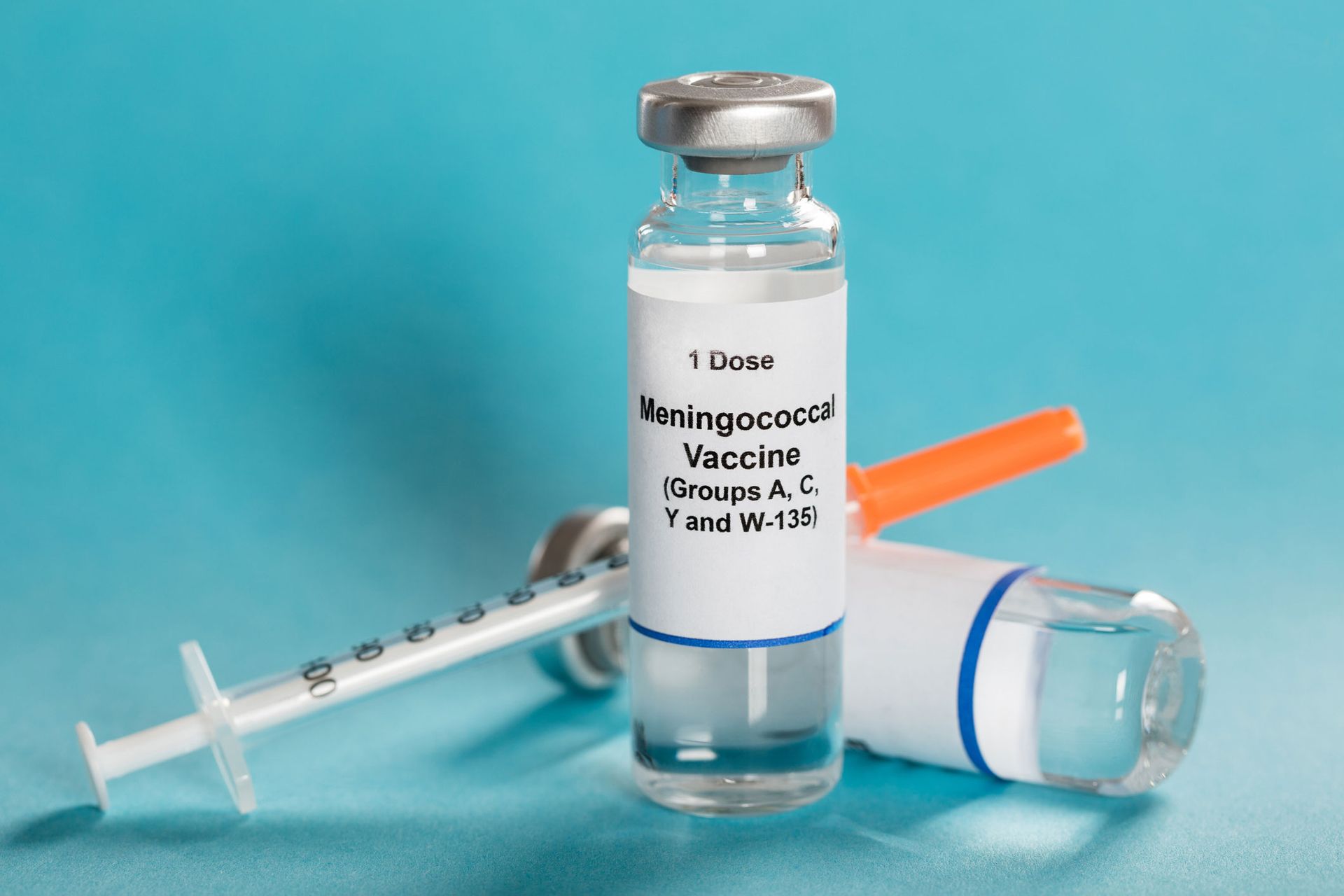 Meningococcal vaccine vial with syringe and needle, on a blue background.